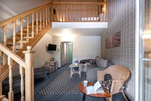 a living room with a staircase and a couch at Nykščio Namai & SPA in Anykščiai