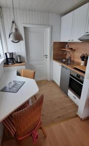 cocina con mesa, sillas y fregadero en Haus Hygge - Ferienwohnung Anker en Boren