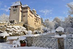 a building covered in snow next to a fence at Ferienwohnung "Josefine und Ihr Kavalier" in Kundl