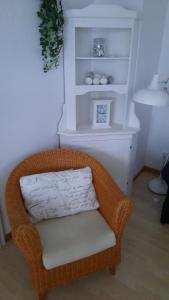 a wicker chair sitting in a room with a shelf at Haus Hygge - Ferienwohnung Hering in Boren