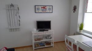 a living room with a tv on a white stand at Haus Hygge - Ferienwohnung Hering in Boren