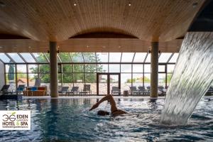 una persona en el agua en una piscina en Hotel Eden Garden Spa, en Câmpulung Moldovenesc