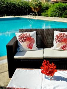 a couch with pillows on it next to a pool at The Home by AN in Lapithos