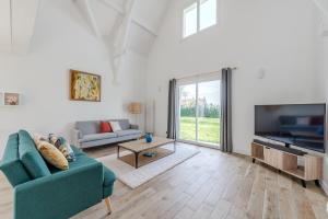 a living room with a blue couch and a tv at Blue Villa near Disneyland Paris in Chalifert