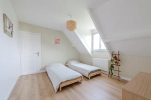 two beds in a room with white walls and wooden floors at Blue Villa near Disneyland Paris in Chalifert +31 photos