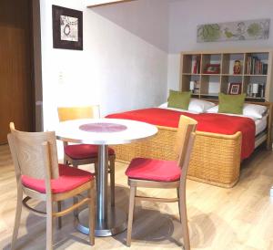 Habitación con cama, mesa y sillas. en Apartment Gala, ruhige Lage, stadtnah en Bad Kissingen
