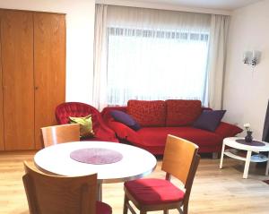 sala de estar con sofá rojo y mesa en Apartment Gala, ruhige Lage, stadtnah en Bad Kissingen
