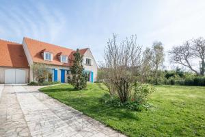 a house with a green yard with a driveway at Blue Villa near Disneyland Paris in Chalifert