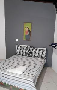 a bed with black and white pillows in a room at Espaço Luz in Paraty
