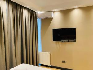 um quarto de hotel com uma televisão de ecrã plano na parede em MyHouseBosphorus em Istambul