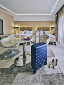 um quarto de hotel com uma mala e um quarto em Hotel Eden Garden Spa em Câmpulung Moldovenesc