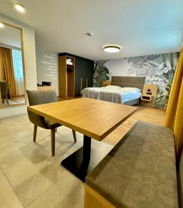 Pokój z drewnianym stołem i łóżkiem w obiekcie Business Appartment by Tinschert w mieście Schwertberg