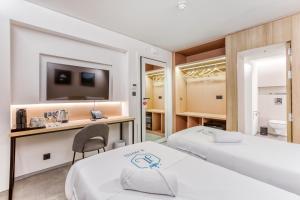 a hotel room with two beds and a desk at JL Hotel in St. Julianʼs