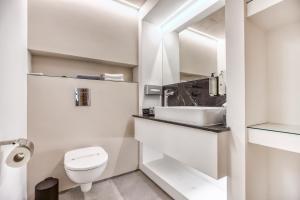Baño blanco con aseo y lavamanos en JL Hotel, en San Julián