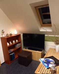 sala de estar con TV de pantalla plana y mesa en Efri Foss, en Staður