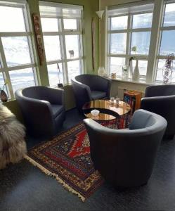 sala de estar con sillas, mesa y ventanas en Efri Foss, en Staður