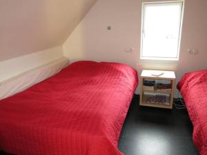 1 dormitorio con 2 camas rojas y ventana en Efri Foss, en Staður