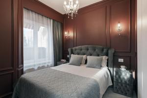 1 dormitorio con cama y lámpara de araña en The Episode - Jacuzzi Penthouses en Cluj-Napoca