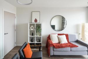 a living room with a couch and a mirror at Canning town -2 bed Luxury Apartment in London