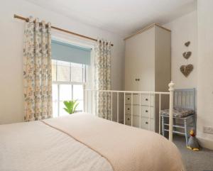 ein Schlafzimmer mit einem Bett, einem Fenster und einem Stuhl in der Unterkunft Stokeinteignhead, South Devon, Character Countryside Apartment in Stokeinteignhead