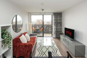 a living room with a couch and a tv at Canning town -2 bed Luxury Apartment in London