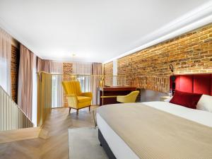 een hotelkamer met een bed en een bakstenen muur bij Golden Queen Deluxe Jacuzzi Apartments - Old Town in Krakau