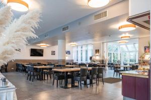 a dining room with tables and chairs in a restaurant at Astoria Business Resort Essen by Mayburgh in Essen