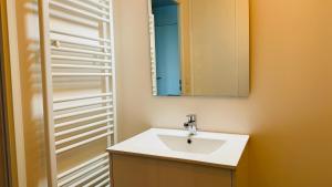 une salle de bains avec un lavabo blanc et un miroir dans l'établissement Baie Dream appartement en front de mer, à Cayeux-sur-Mer 12 autres photos