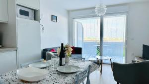 d'un salon avec une table et des plaques de cuisson. dans l'établissement Baie Dream appartement en front de mer, à Cayeux-sur-Mer