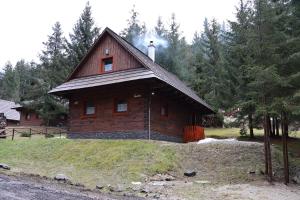 ein kleines Holzhaus auf einem Hügel mit Bäumen in der Unterkunft Jariabka Chalet Zrub Nízke Tatry in Jarabá