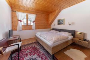 a bedroom with a bed and a wooden ceiling at Hiša Ojstrica in Solčava