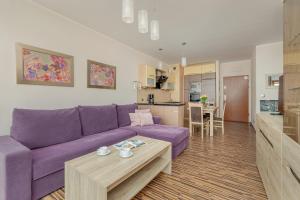 a living room with a purple couch and a table at Spacious Apartment with Balcony in Świnoujście Center by Renters in Świnoujście