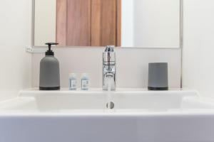 a bathroom sink with a bottle of soap and a soap dispenser at GuestReady - Virtudes Apartment Balcony 1 in Porto