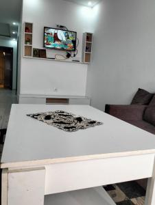 un tavolo bianco in un soggiorno con TV di APPARTEMENT AMINE a Delmonte