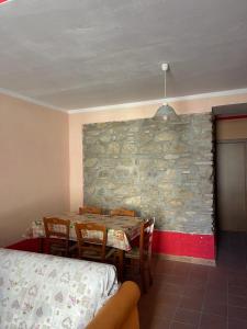 comedor con mesa, sillas y pared de piedra en Casa Manzo, en Montemurro