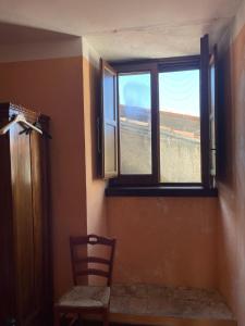 Habitación con ventana con silla y mesa en Casa Manzo, en Montemurro