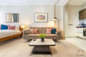 salon z kanapą i łóżkiem w obiekcie Royal Studio Apartment in Mayfair w Londynie