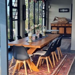 a dining room with a wooden table and chairs at Living on a Golf Estate in Mossel Bay