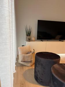 a living room with a tv and a chair at Studio-be in Nieuwpoort +24 photos