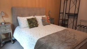 a bedroom with a bed with white sheets and pillows at Chapter Farm Cottages in Canterbury
