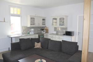 a living room with a couch and a kitchen at Ferienhaus "Waldidyll Brunni" in Marlow