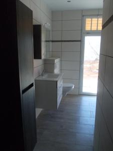 ein Bad mit einem Waschbecken, einem WC und einem Fenster in der Unterkunft Ferienhaus "Waldidyll Brunni" in Marlow