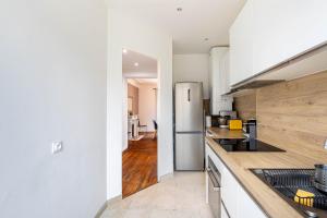 een keuken met witte werkbladen en een koelkast bij GuestReady -Apt familial en bordure de la Capitale in Levallois-Perret +8 foto's