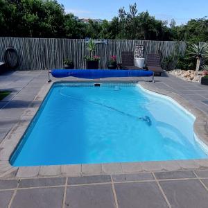 a large blue swimming pool in a yard at Living on a Golf Estate in Mossel Bay