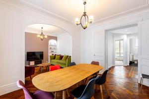 een eetkamer met een houten tafel en stoelen bij GuestReady -Apt familial en bordure de la Capitale in Levallois-Perret