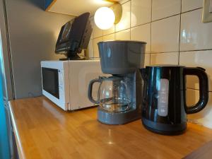 two coffee pots sitting on a counter next to a microwave at Ferienwohnung Pünter in Surwold