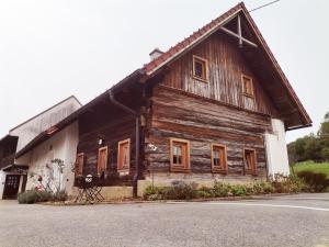 uma antiga casa de madeira ao lado de uma rua em Landhaus Schusterfranz em Passail