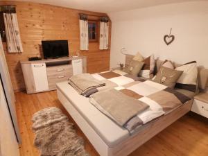 a bedroom with a large bed and a television at Landhaus Schusterfranz in Passail