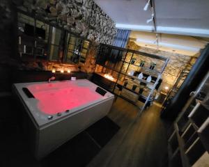a large bathroom with a red bath tub at Romantic Room Loft Déco Balnéo Jacuzzi Authentique, Centre, Climatisation in Sète
