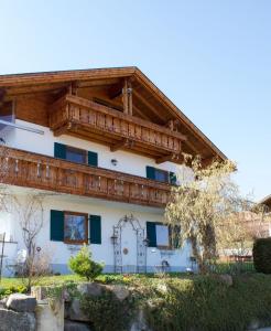 een wit huis met een houten dak bij Panoramaausblick auf Berge, See und Ort in ruhiger Lage in Lechbruck